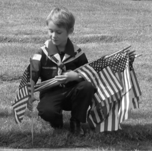 Boy scout Chas holding flags bw